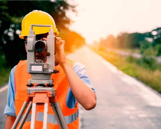 Surveyor using a total station to carry out a land survey
